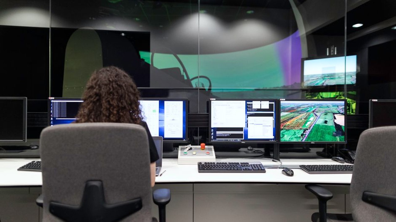 Logistics professional analyzing car shipping routes and real-time data on multiple computer screens in a modern control room