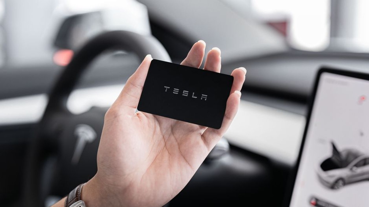 Enclosed car transporter showing a Tesla being secured, highlighting the care taken for luxury and electric vehicles during transport