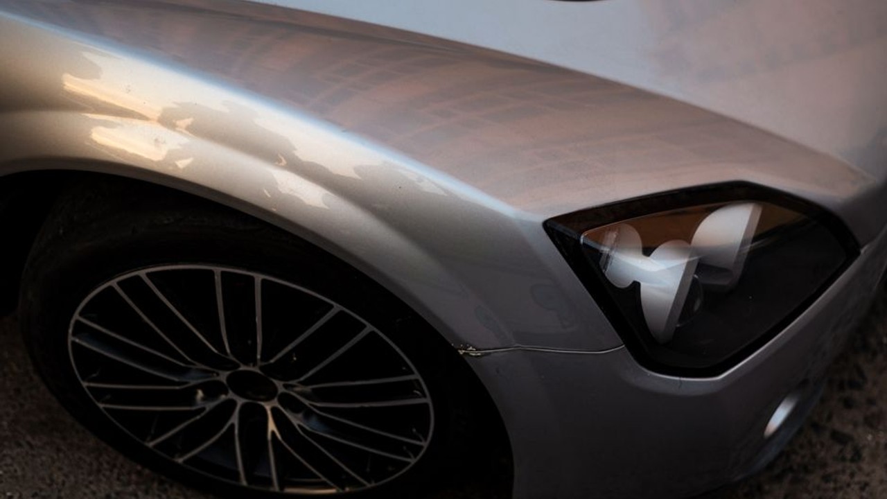 Detail of a car carrier's robust strapping and wheel nets securing a modern electric sedan to prevent movement during long distance vehicle transport