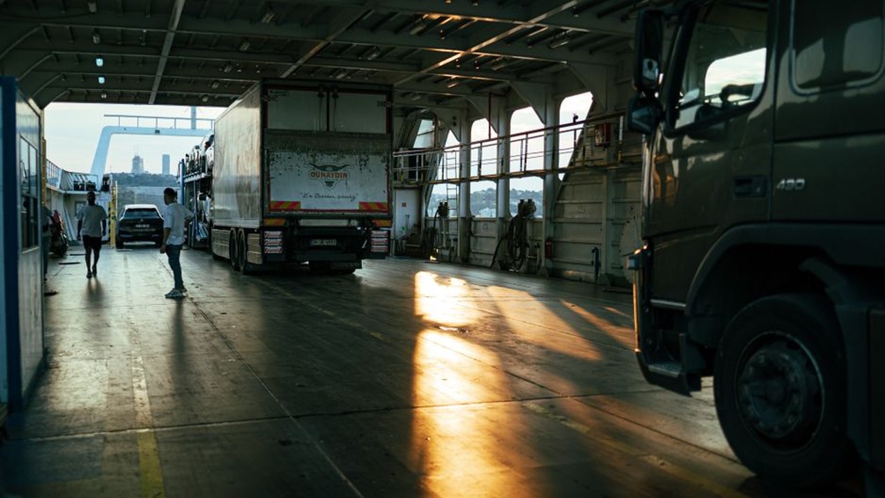 Military family waving goodbye to a professional car carrier truck shipping their vehicle for a cross-country PCS move