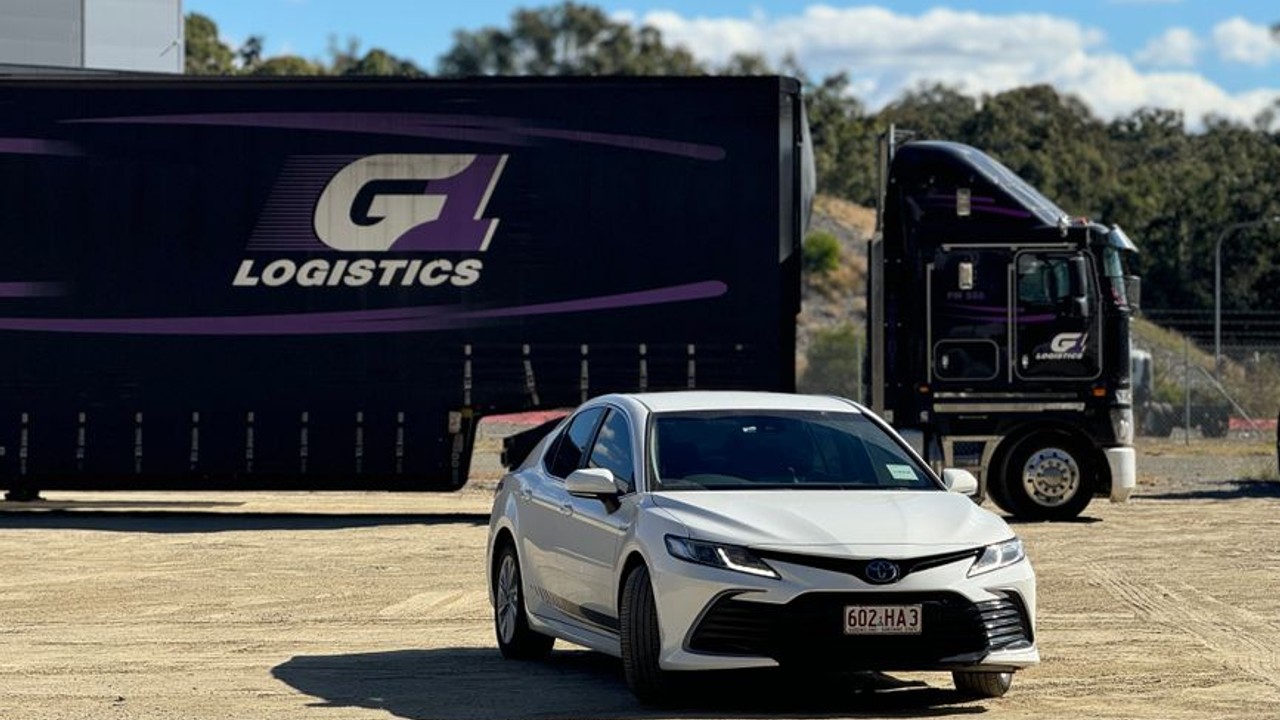 A family car being loaded onto a multi-car shipping trailer, representing the start of a cross-country move and the associated logistics and fees