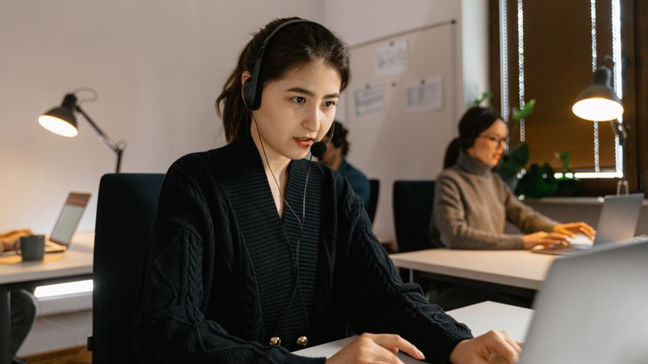 A professional and friendly customer service representative speaking on the phone, providing auto transport solutions for a car shipping company.