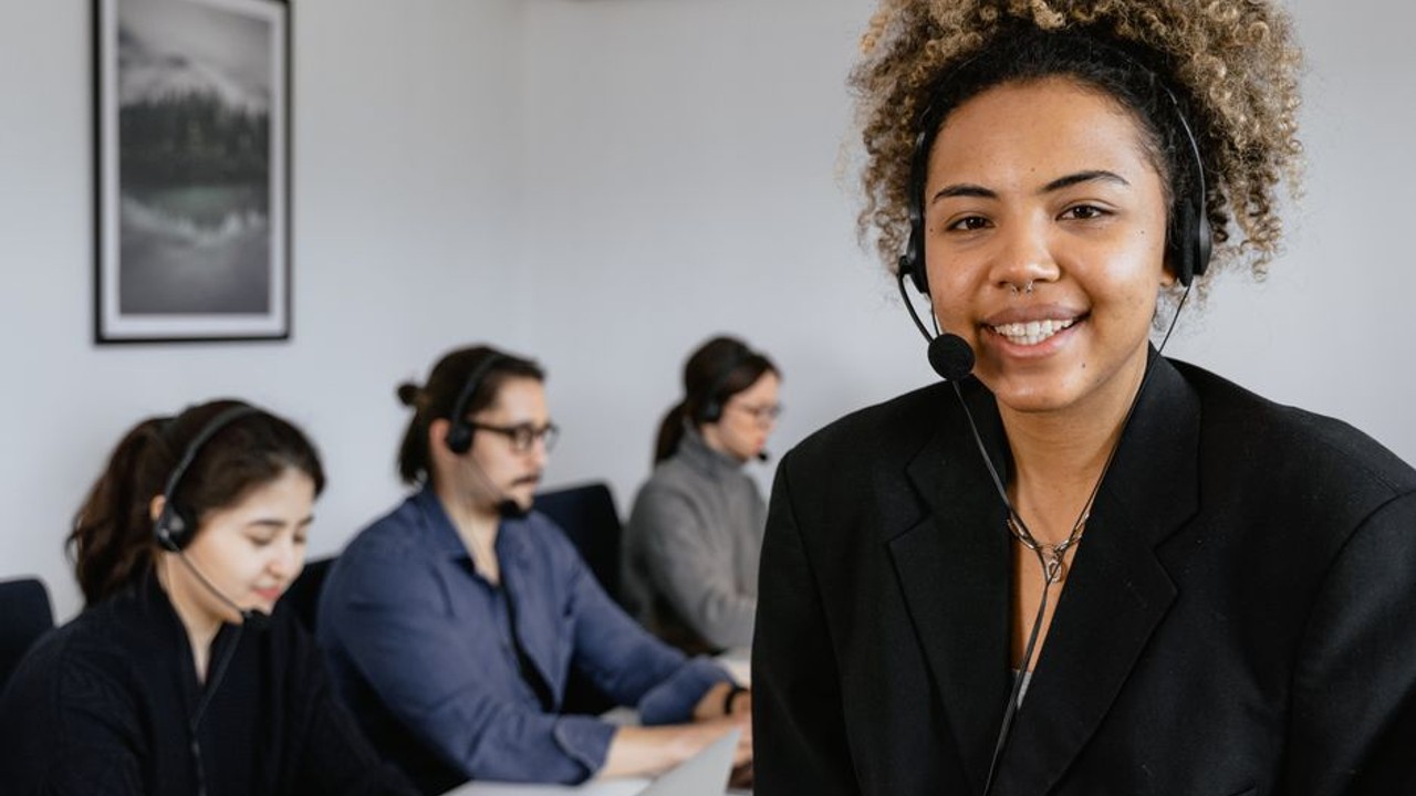 Professional customer service representative assisting a client on the phone at a car shipping office, emphasizing reliable support