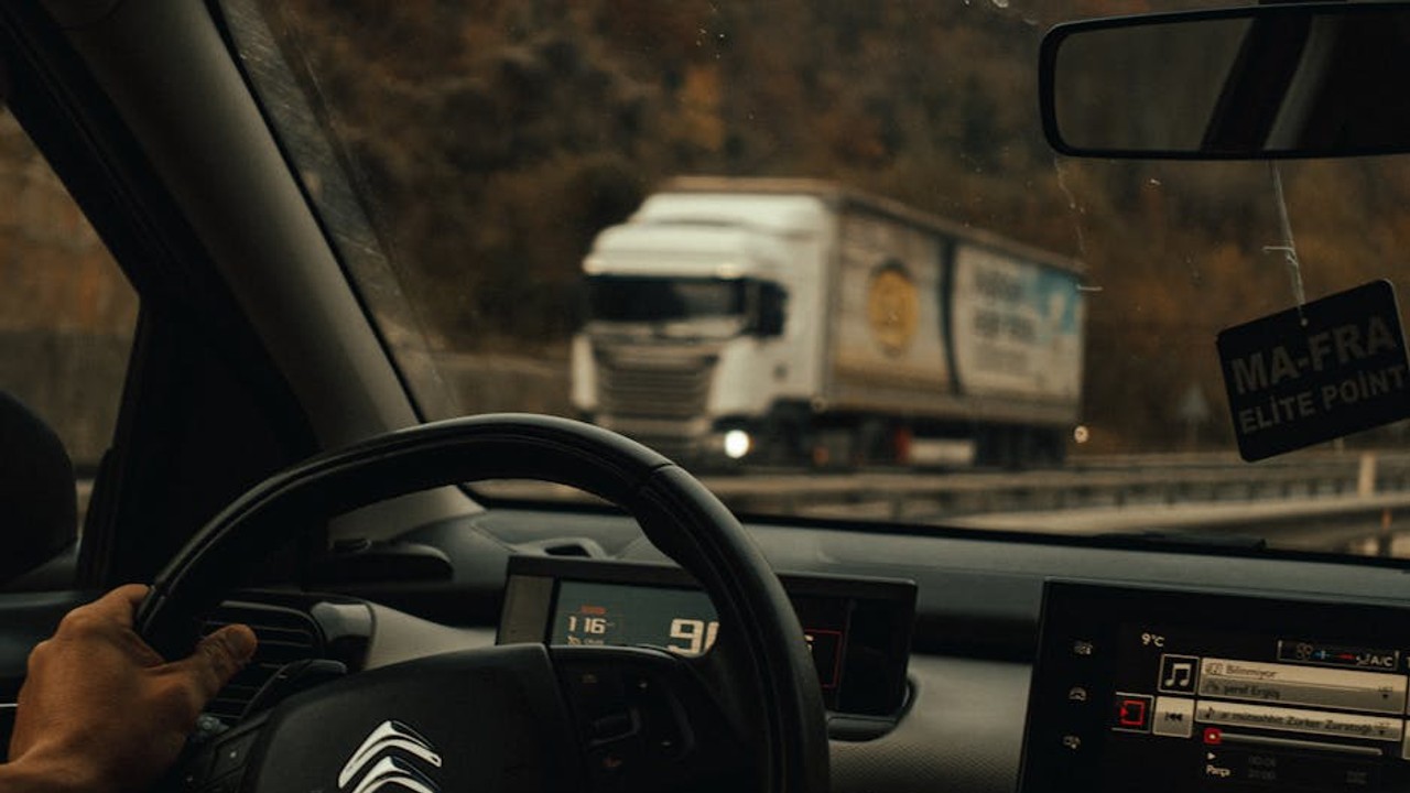 Dashboard view from a car transport truck on a long road, symbolizing the journey of cross country shipping