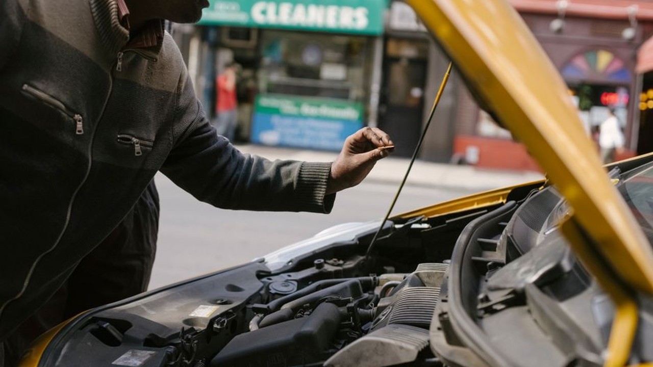A person examining a car for new damage upon delivery from cross-country transport