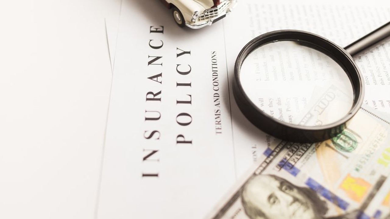 Insurance policy documents and a pen, symbolizing car shipping insurance coverage and legal agreement