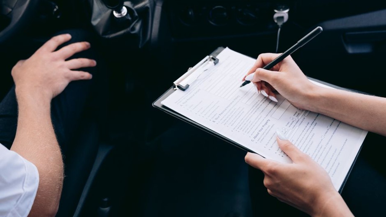 Bill of Lading document being signed by a car owner and a truck driver, showing vehicle inspection details