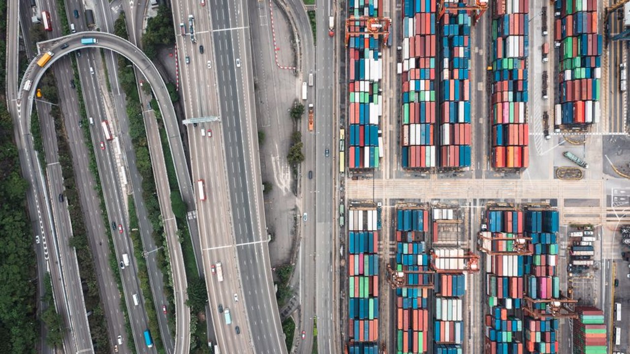Overhead view of an interstate highway interchange with numerous cars, symbolizing busy transportation networks and logistics